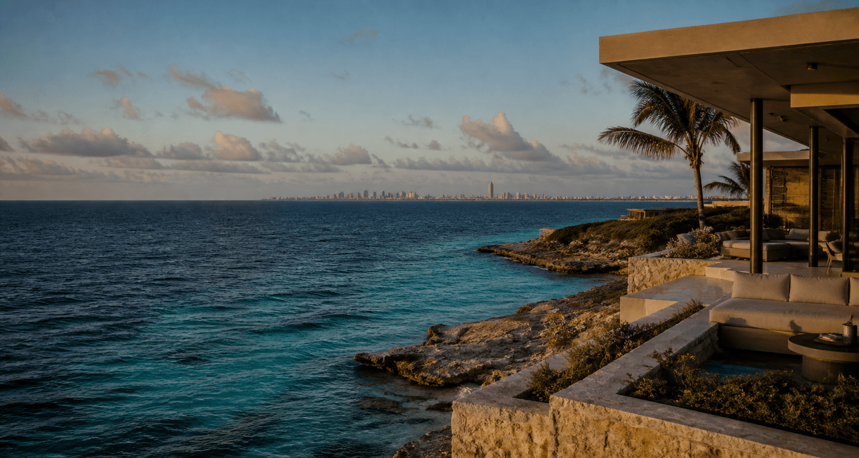Caribbean coastline with a distant city skyline at sunset